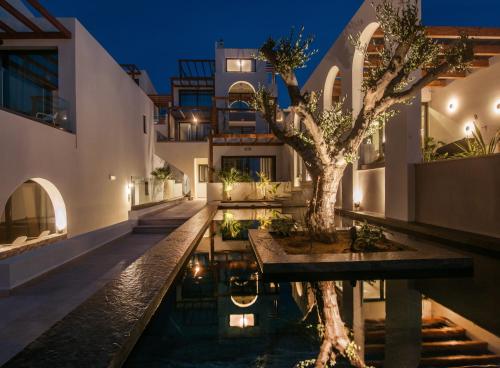 a house with a tree in the middle of a pool at VAYA Suites by Omilos Hotels in Amoudara Herakliou