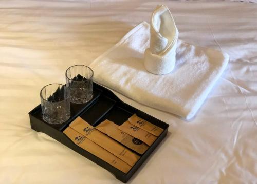 Tân PhúNam Cat Tien Retreat的一盘酒杯和餐巾纸上的一只鞋