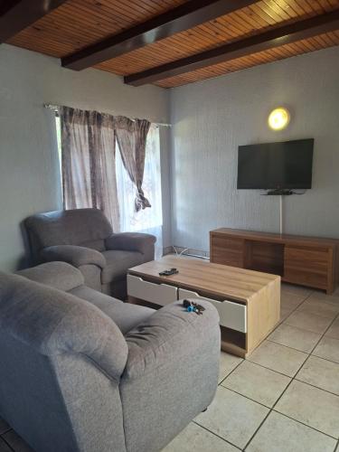 un salon avec deux canapés et une télévision à écran plat dans l'établissement Number 8, à Maseru