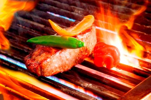 a piece of meat and vegetables on a grill at Hotel An der Sauer in Minden