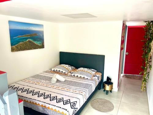 een slaapkamer met een bed met uitzicht op de oceaan bij Petit Chalet in Baie-Mahault