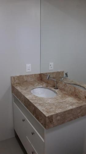 a bathroom counter with a sink and a mirror at Apto 3 quartos Centro Torres RS in Torres