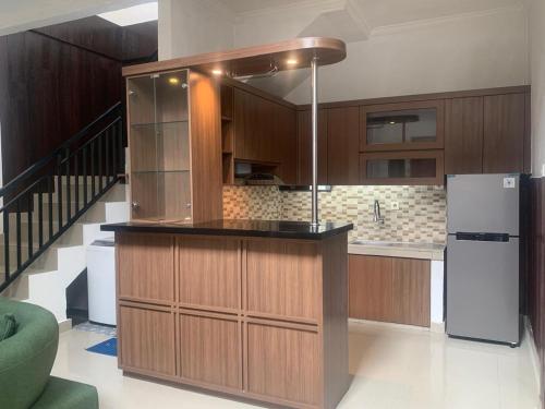 eine Küche mit Holzschränken und einem Kühlschrank in der Unterkunft Cahaya Residence The Guest House in Kuta