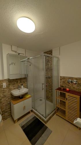 a bathroom with a glass shower and a sink at Marco City Apartment Werne - Terrasse, Küche & WLAN in Werne an der Lippe
