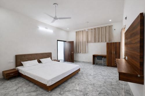 een slaapkamer met een groot bed en een bureau bij Takery Resort in Chittaurgarh