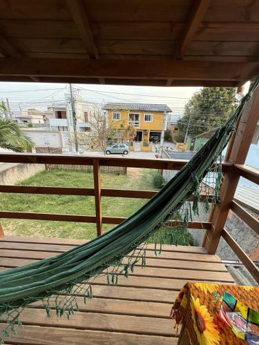 a hammock on a porch with a view of a street at Casa no Norte da Ilha in Florianópolis