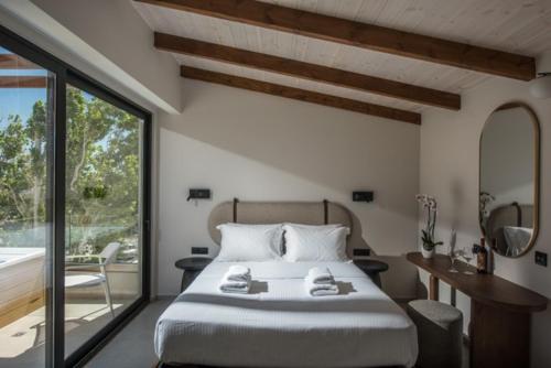 a bedroom with a large bed and a balcony at VAYA Suites by Omilos Hotels in Amoudara Herakliou