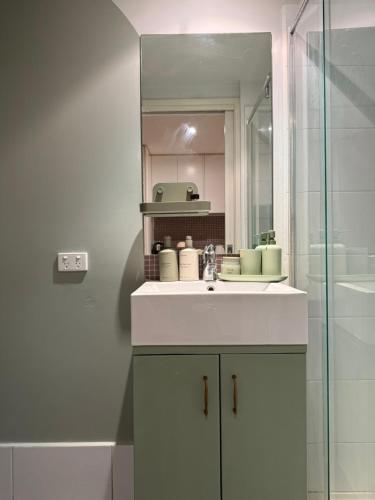 een badkamer met een wastafel en een douche bij Cosy Footscray Studio - 2 Guests in Melbourne
