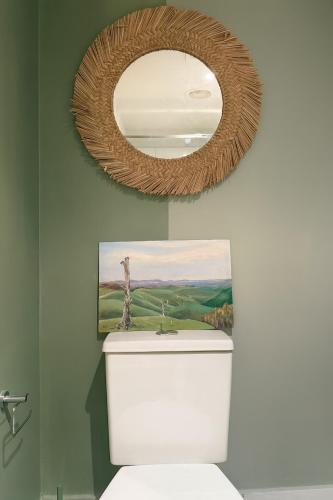 a bathroom with a mirror above a toilet at Cosy Footscray Studio - 2 Guests in Melbourne
