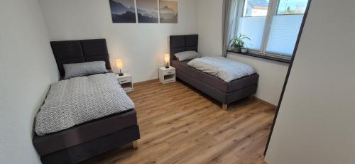 two beds in a room with a mirror at M&M AusZeit im Schwabenländle in Winterlingen