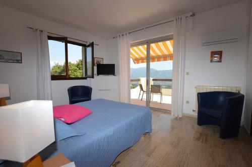 - une chambre avec un lit, des chaises et un balcon dans l'établissement Villa la Chiosella, à Valle-di-Mezzana