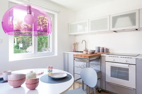 a kitchen with a table and a pink chandelier at 4Stubenhaus in Dornbirn