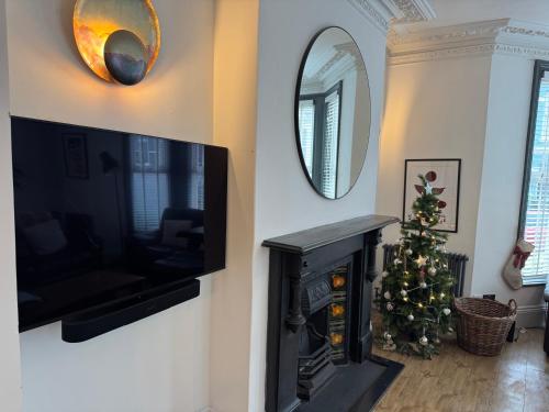 a living room with a christmas tree and a mirror at Large Home Sleeps 6 Central Location Free Parking in Plymouth