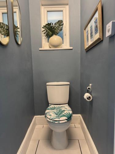 a bathroom with a toilet and a window at Large Home Sleeps 6 Central Location Free Parking in Plymouth