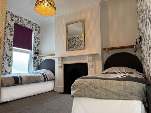 a bedroom with two beds and a fireplace at Large Home Sleeps 6 Central Location Free Parking in Plymouth