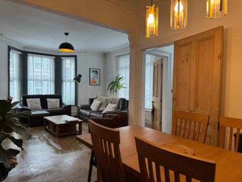 a living room with a table and a couch at Large Home Sleeps 6 Central Location Free Parking in Plymouth