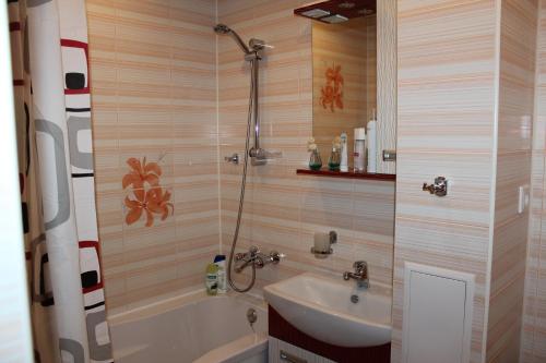 een badkamer met een douche, een wastafel en een bad bij Apartments 4 Mikrorayon in Tichvin