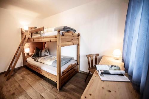 een slaapkamer met twee stapelbedden en een bureau bij Oberhof Apt Lärchenwald in Vallarga