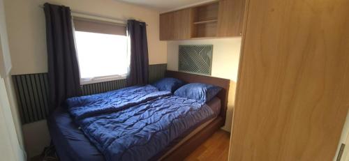 een bed in een slaapkamer met een raam bij RBR 662 - Beach Resort Kamperland in Kamperland