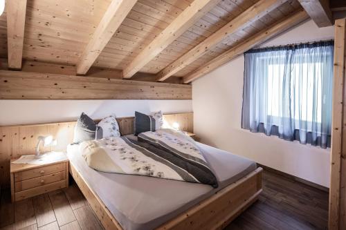 een groot bed in een kamer met een houten plafond bij Oberhof Apt Panorama in Vallarga