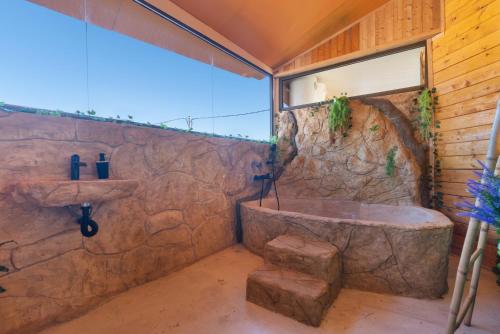 een stenen badkamer met een wastafel en een bad bij El mágico Refugio de las Vegas in Valsequillo