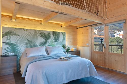 een slaapkamer met een bed en een groot raam bij El mágico Refugio de las Vegas in Valsequillo