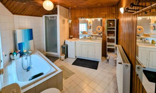 een grote badkamer met een bad en twee wastafels bij Chambre Chez Lou in Bucey-lès-Gy