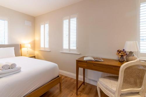 a bedroom with a desk and a bed and windows at GuestReady Cozy Dublin Hideaway in Dublin