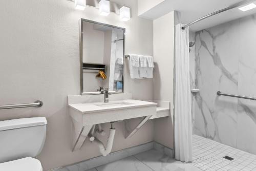 a bathroom with a sink and a toilet and a mirror at Best Western Starke in Starke