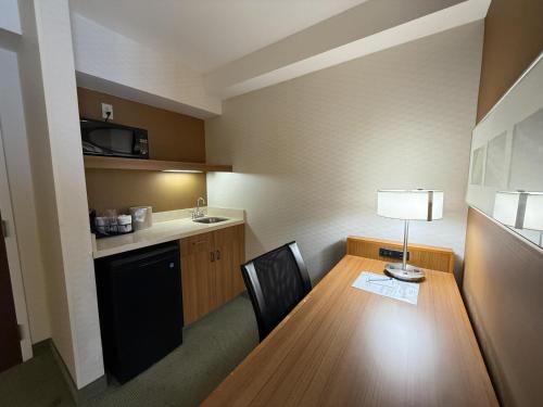 a small room with a table and a kitchen at The Peoria Hotel, SureStay Collection by Best Western in Peoria