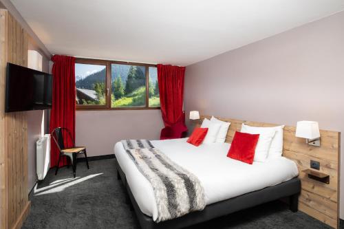 een hotelkamer met een groot bed met rode kussens bij SOWELL Family Valfrejus in Valfréjus