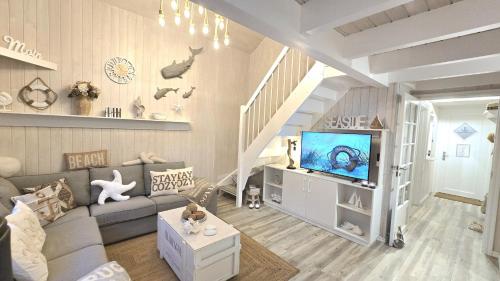 a living room with a couch and a tv at Strandhaus Rügen 243 in Baabe