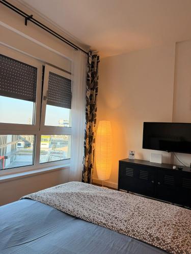 a bedroom with a bed and a flat screen tv at Fantasia apartmani - Tesla palace in Kragujevac