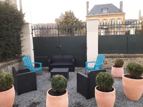 a patio with chairs and plants in front of a fence at Grand appart 2 chambres - max 6 pers in Vrigne-aux-Bois
