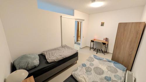 a small bedroom with a bed and a desk at Marco City Apartment Werne - Terrasse, Küche & WLAN in Werne an der Lippe