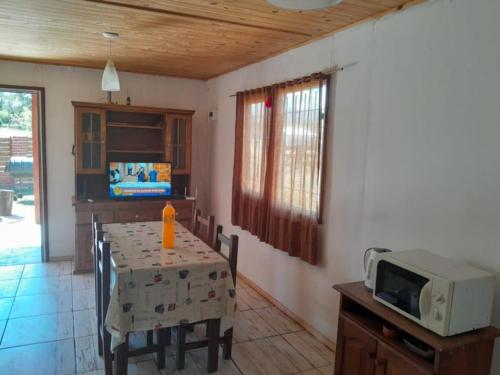 a kitchen with a table and a microwave at Cabaña Juana Vg in Villa Giardino