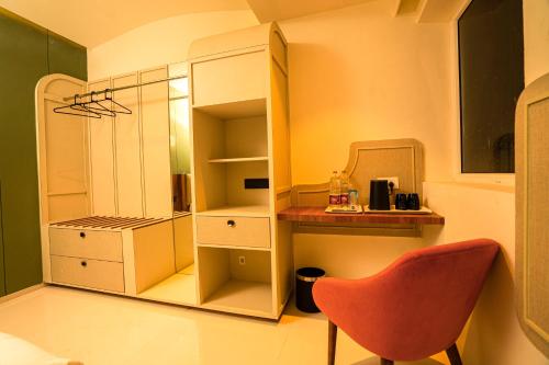 een keuken met een rode stoel en een kast bij Hotel Harriet in Rāmeswaram