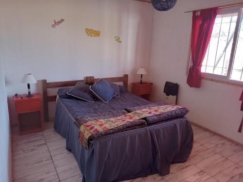 a bedroom with a bed with blue sheets and pillows at Cabaña Juana Vg in Villa Giardino