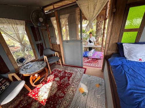 a person sitting at a table in a tiny house at Faiza Farm home in Ban Nong Phai