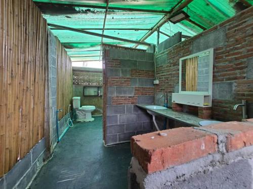 a brick bathroom with a sink and a toilet at Faiza Farm home in Ban Nong Phai