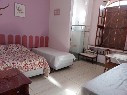 een kleine slaapkamer met twee bedden en een raam bij Pousada Chácara Famille Brun in São João da Boa Vista