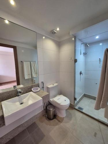 a bathroom with a sink and a toilet and a shower at Vista Azul Apart Hotel - Vista Pinheiros in Pedra Azul