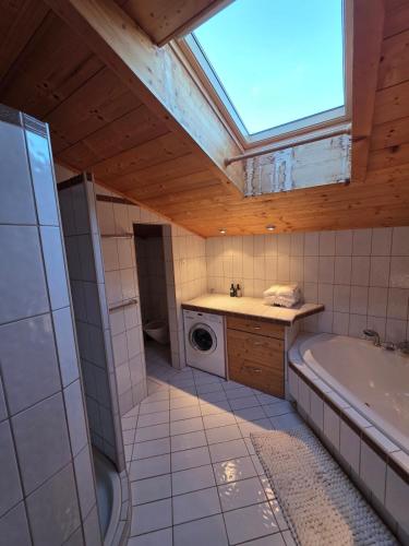 a bathroom with a tub and a sink and a window at Glory Igls Lodge in Innsbruck