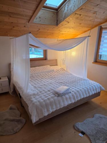 a bedroom with a bed with a mosquito net at Glory Igls Lodge in Innsbruck