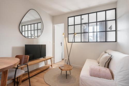 een woonkamer met een witte bank en een spiegel bij Marrakech - Gare - CEA - STMicro in Fontaine