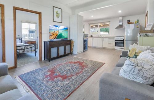 a living room with a couch and a flat screen tv at Armstrong Cottage in Paynesville