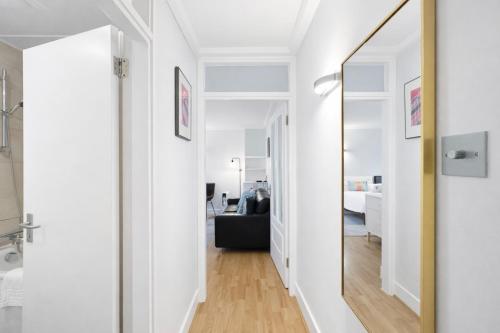 un couloir avec un miroir et un salon dans l'établissement Camden Serviced Apartments by Globe Apartments, à Londres