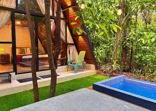 une maison avec une piscine dans un jardin dans l'établissement Kandy Little White House Cabanas, à Kandy