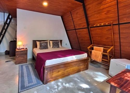 une chambre avec un lit dans une pièce aux murs en bois dans l'établissement Kandy Little White House Cabanas, à Kandy