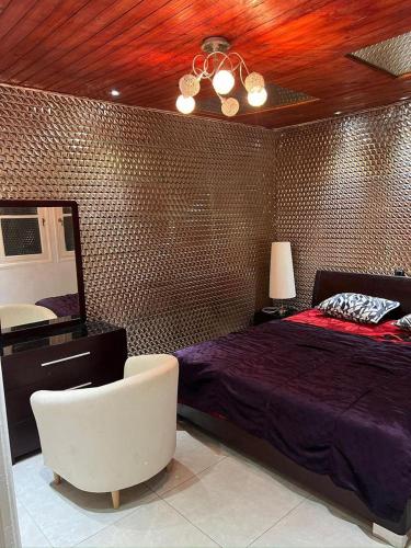 une chambre avec un lit, une chaise et un miroir dans l'établissement Saidia luxury, à Saïdia